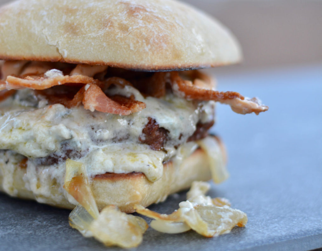 Mountain Burger with ciabatta bun, caramelized onion, bacon, and the most amazing cheese ever!