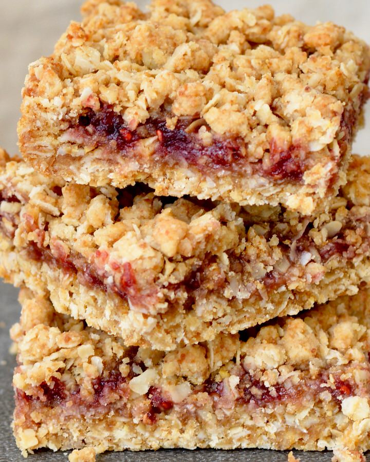 Berry Oat Bars with No Refined Sugar. Simple recipe, ready in less than 30 minutes. Raspberry preserves tucked inside layers of crumbly oat mixture. Perfect for breakfast or dessert!