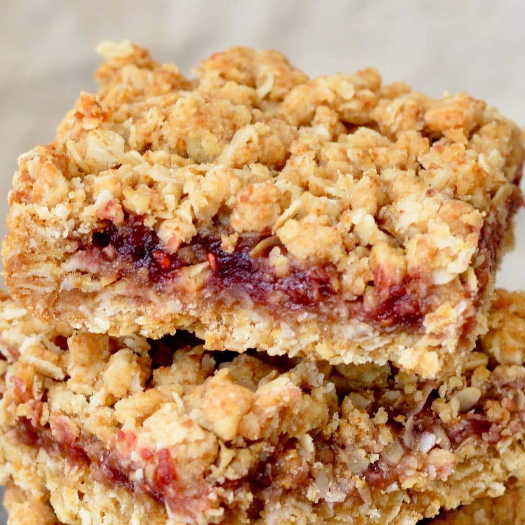 Berry Oat Bars with No Refined Sugar. Simple recipe, ready in less than 30 minutes. Raspberry preserves tucked inside layers of crumbly oat mixture. Perfect for breakfast or dessert!