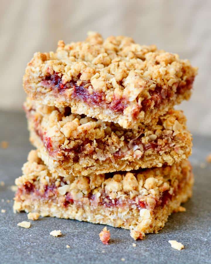 Berry Oat Bars with No Refined Sugar. Simple recipe, ready in less than 30 minutes. Raspberry preserves tucked inside layers of crumbly oat mixture. Perfect for breakfast or dessert!