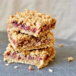 Berry Oat Bars with No Refined Sugar. Simple recipe, ready in less than 30 minutes. Raspberry preserves tucked inside layers of crumbly oat mixture. Perfect for breakfast or dessert!