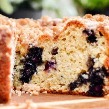 Inside a blueberry muffin cake sitting on wood cutting board.