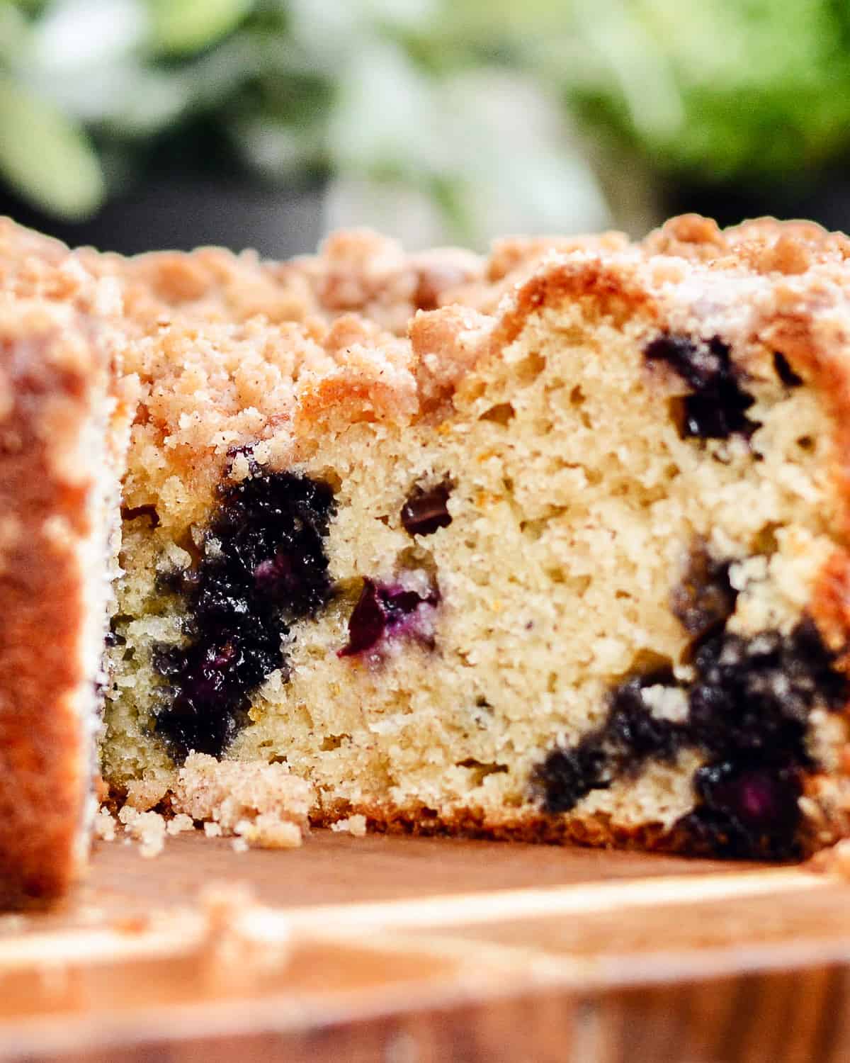 Inside a blueberry muffin cake sitting on wood cutting board.