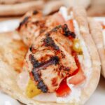 Chicken Tawook Pita Sandwich - Lebanese flavors with grilled chicken, perfectly spiced marinade and sauces, along with tomatoes, pickles and packed with tons of authentic, but easy flavor. #tawook #lebanese #chickendinner