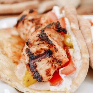 Chicken Tawook Pita Sandwich - Lebanese flavors with grilled chicken, perfectly spiced marinade and sauces, along with tomatoes, pickles and packed with tons of authentic, but easy flavor. #tawook #lebanese #chickendinner