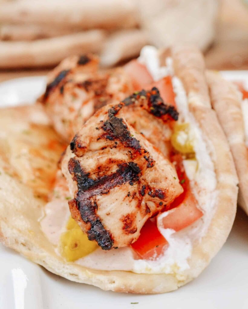 Chicken Tawook Pita Sandwich - Lebanese flavors with grilled chicken, perfectly spiced marinade and sauces, along with tomatoes, pickles and packed with tons of authentic, but easy flavor. #tawook #lebanese #chickendinner