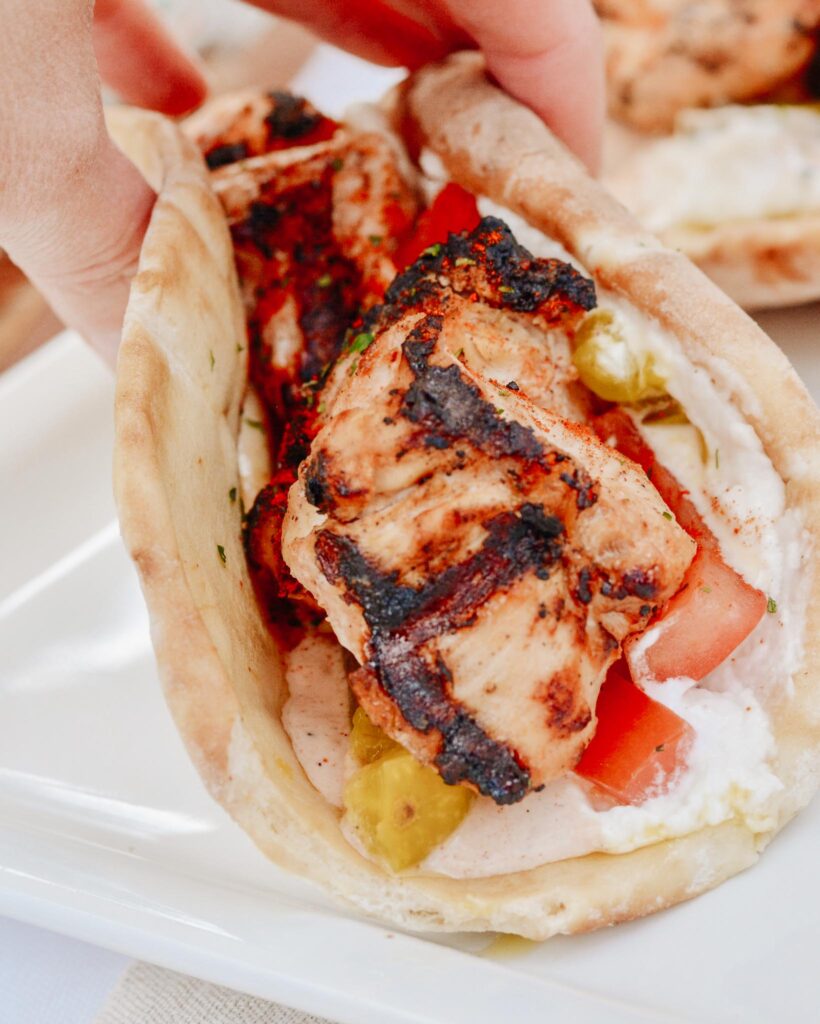 Chicken Tawook Pita Sandwich - Lebanese flavors with grilled chicken, perfectly spiced marinade and sauces, along with tomatoes, pickles and packed with tons of authentic, but easy flavor. #tawook #lebanese #chickendinner