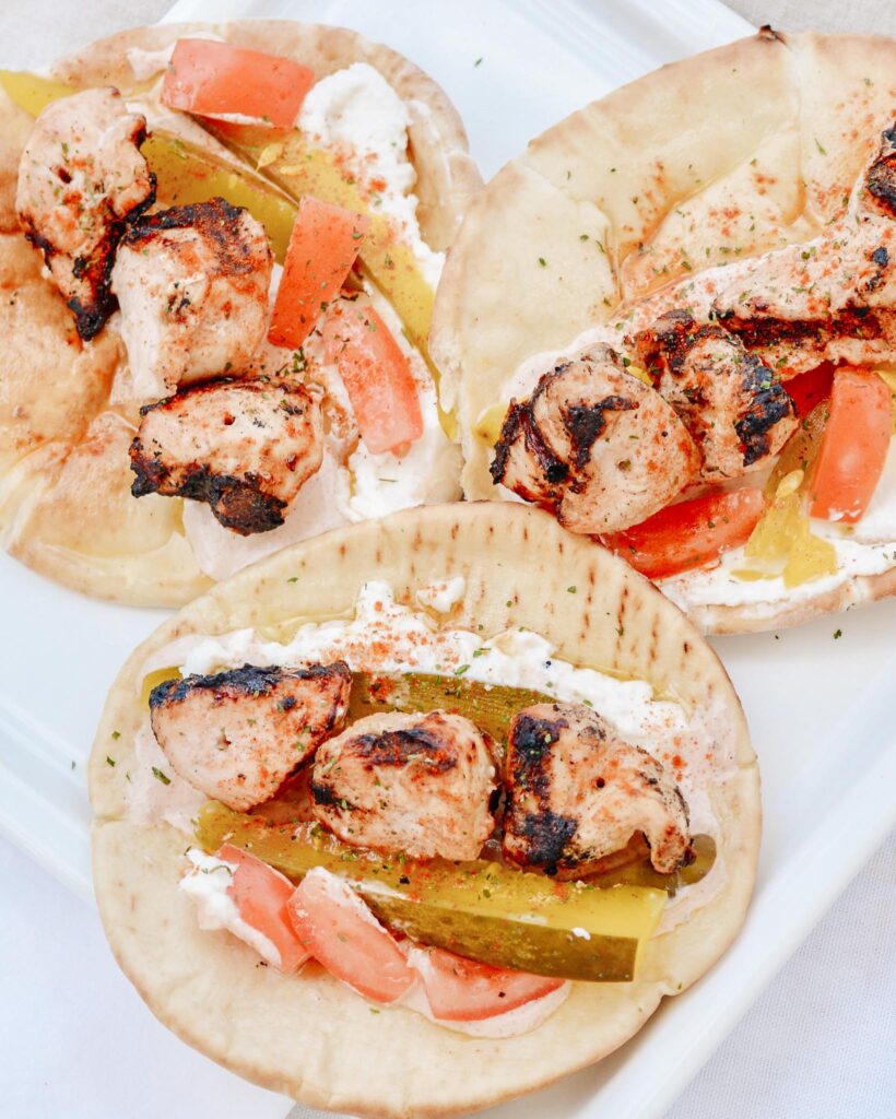 Chicken Tawook Pita Sandwich - Lebanese flavors with grilled chicken, perfectly spiced marinade and sauces, along with tomatoes, pickles and packed with tons of authentic, but easy flavor. #tawook #lebanese #chickendinner
