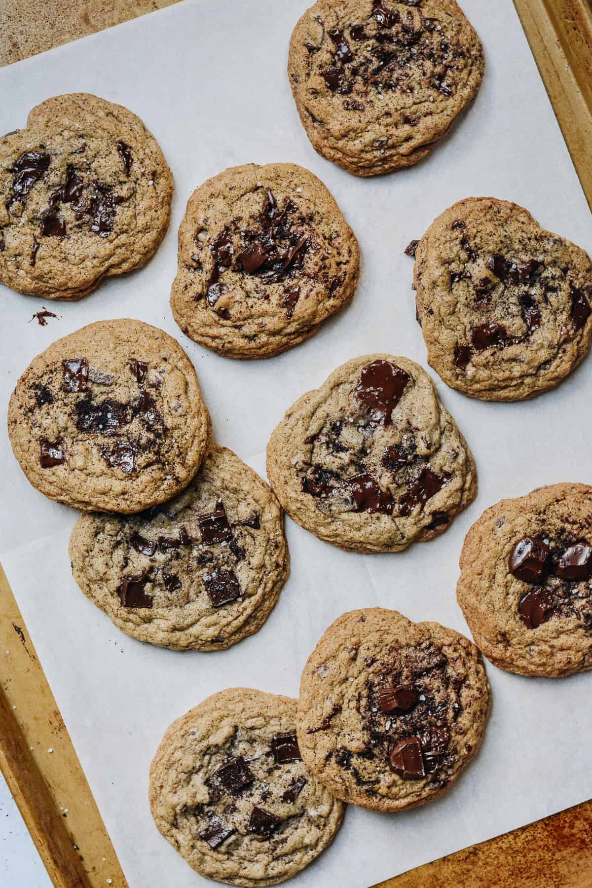 Baking sheet with lots of cookies on a parchment sheet.