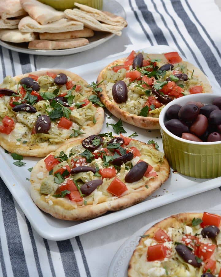 Easy Greek Pizza Recipe - Hummus, Feta, Tomatoes, Kalamata Olives, Artichoke Hearts, Fresh Parsley and Olive Oil.