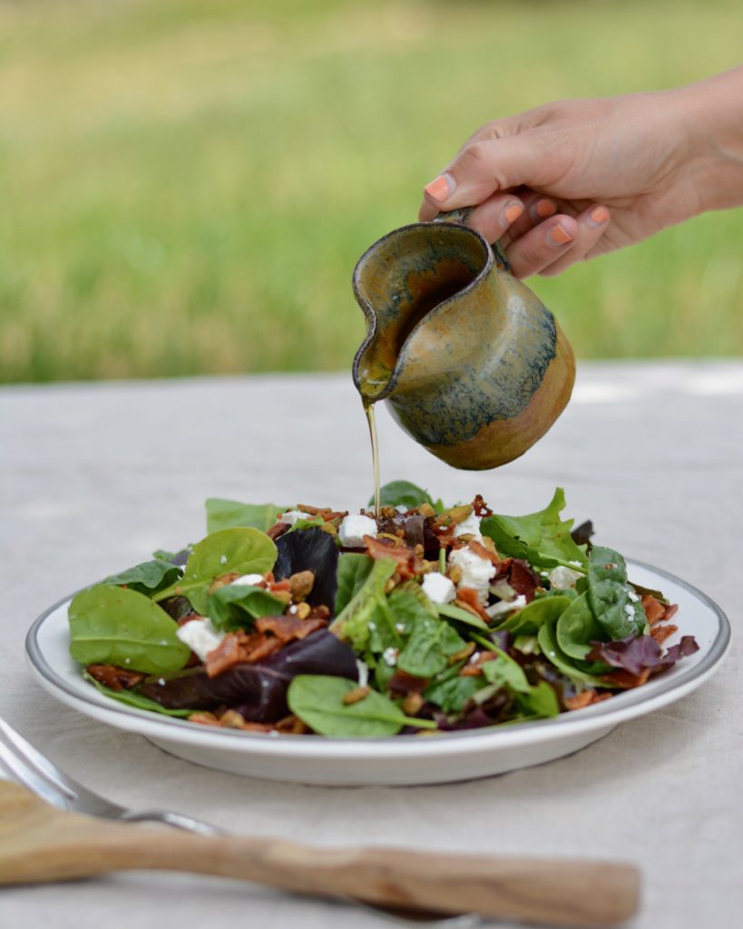 Italian Bacon Salad with warm homemade apricot dressing. Goat cheese, pistachios, bacon and spring mix salad.