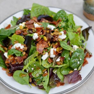 Italian Bacon Salad with warm homemade apricot dressing. Goat cheese, pistachios, bacon and spring mix salad.