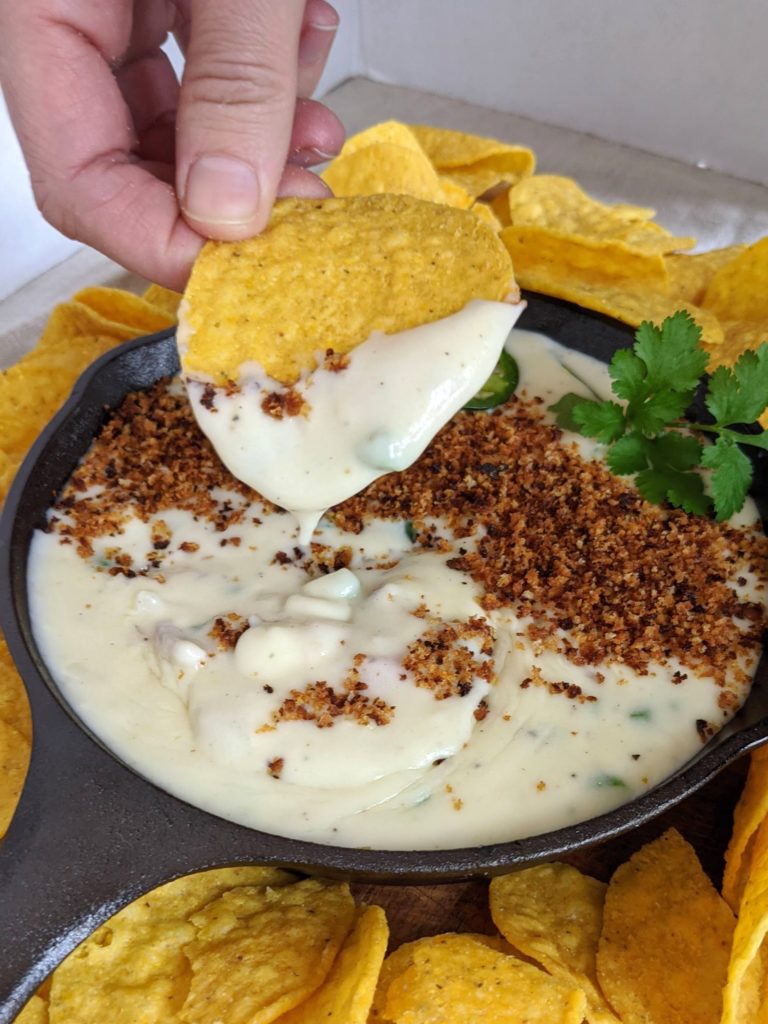 The BEST queso dip with jalapeño, red onion, monterey jack cheese. Topped with bread crumbs, jalapeños and cilantro. Seriously the most amazing queso ever.