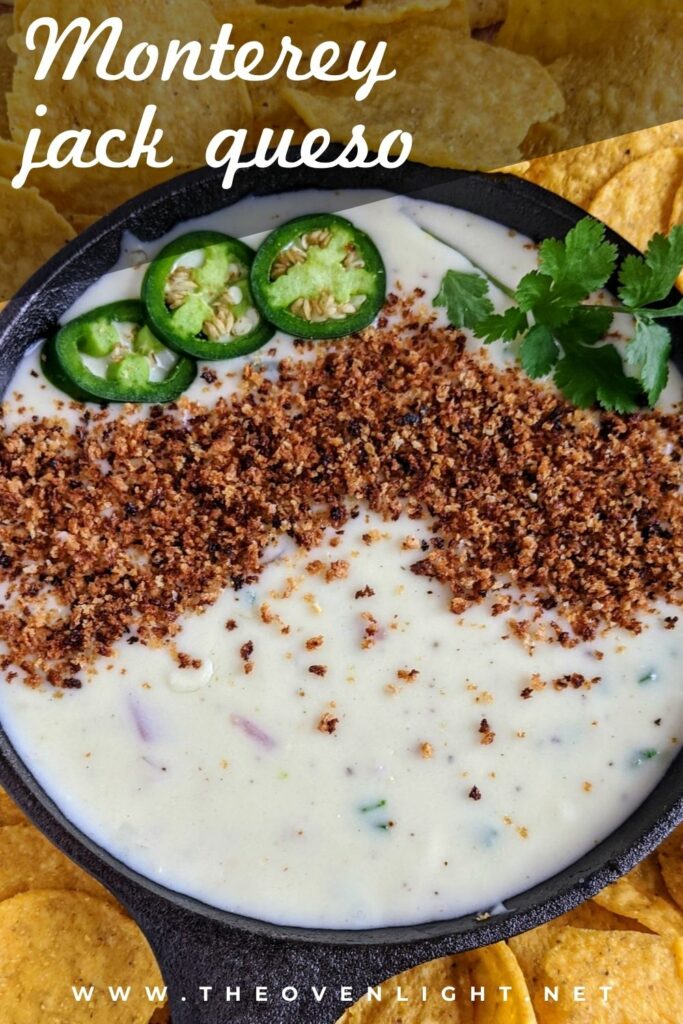 The BEST queso dip with jalapeño, red onion, monterey jack cheese. Topped with bread crumbs, jalapeños and cilantro. Seriously the most amazing queso ever. #queso #cheesedip #chipdip