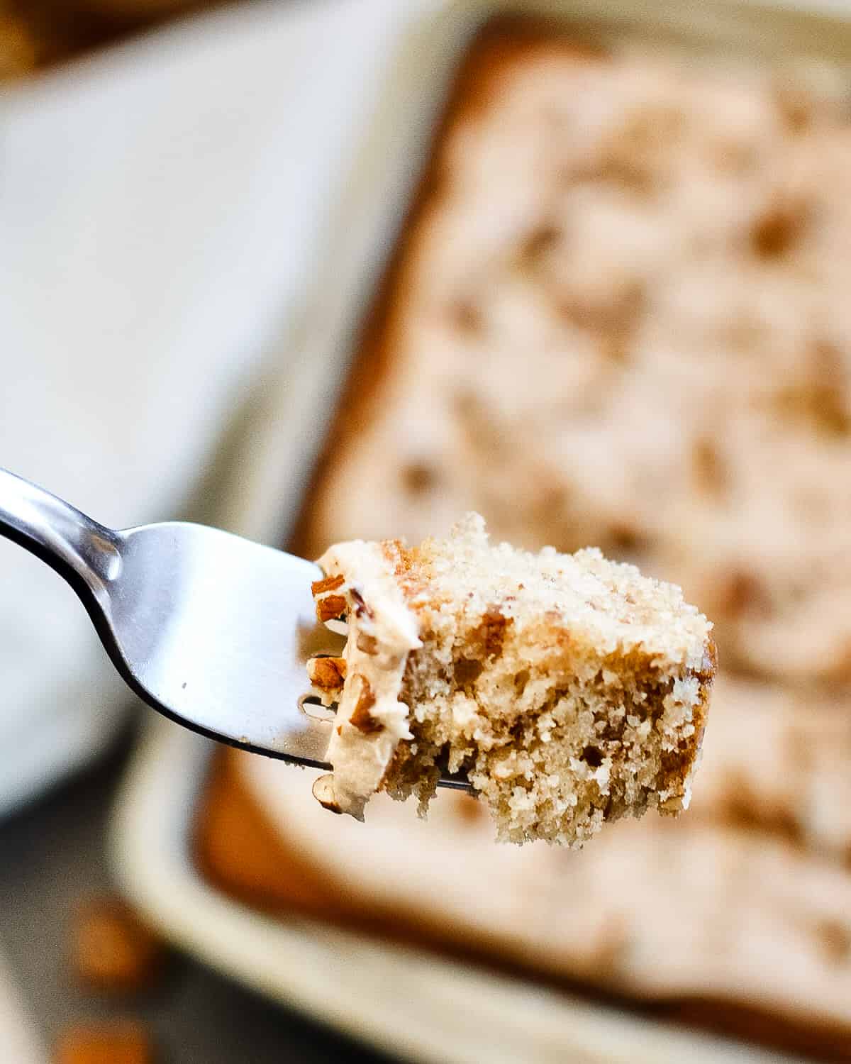 Up close of fork with a piece of pecan cake.