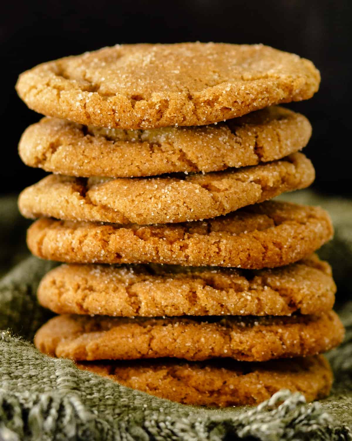 Close up of molasses cookies on green fabric.