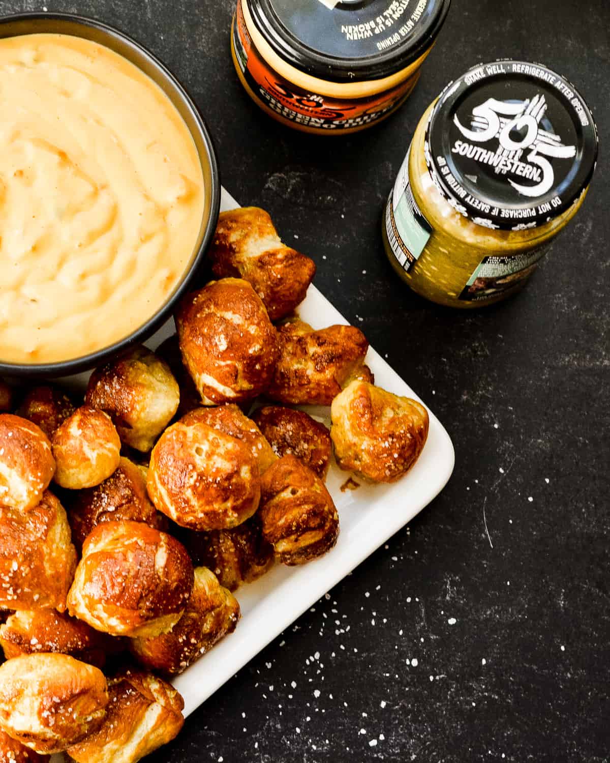 Small pretzel bites with queso and tomatillo salsa.