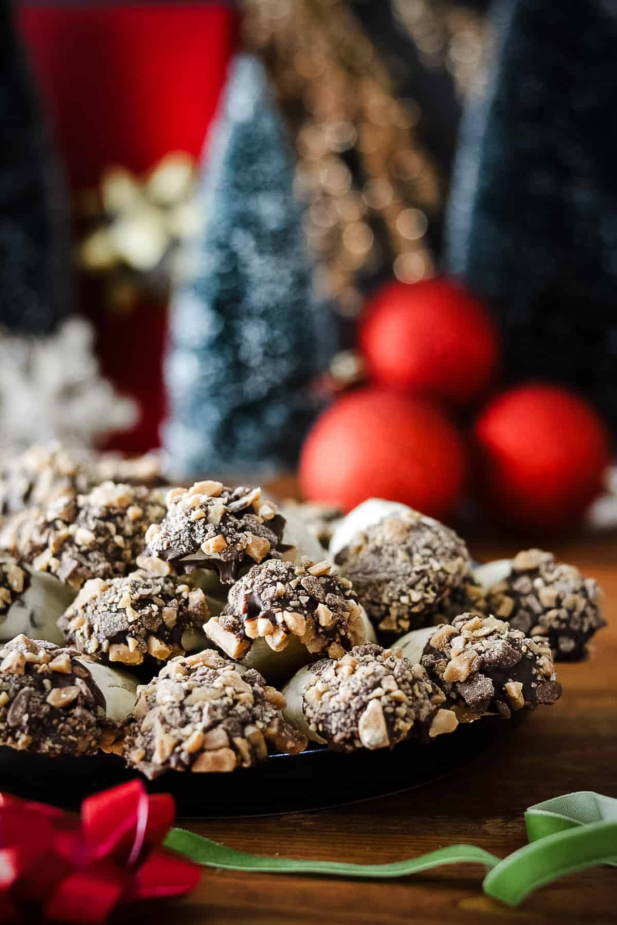 Cookies on a plate with a christmas tree and ornaments in background.