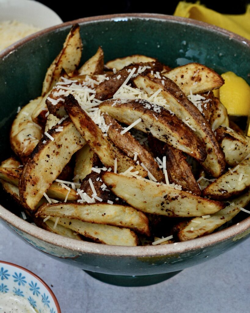 Lemon Parmesan Baked Potato Wedges | Skin-on Fries baked with lemon, butter and parmesan to create a completely delicious and surprising side dish.