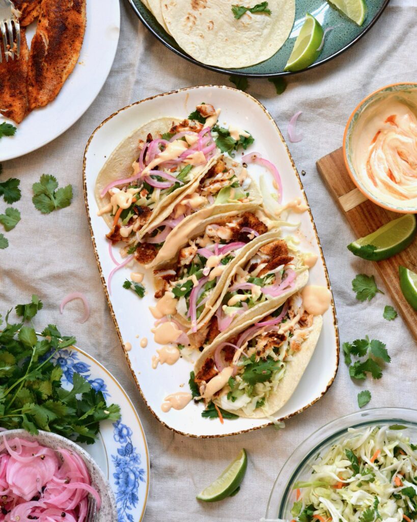 Super easy Blackened Fish Tacos with Tilapia, cilantro slaw and 2 ingredient sauce. Delicious taco night and summer meal.