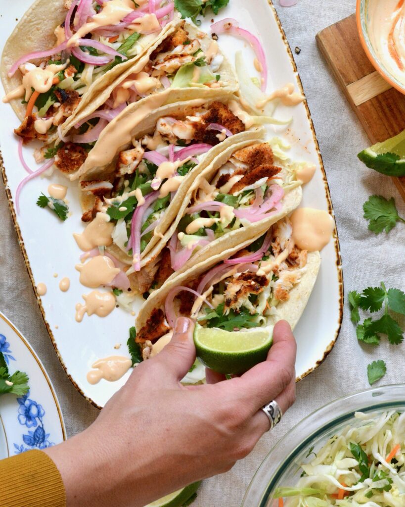 Super easy Blackened Fish Tacos with Tilapia, cilantro slaw and 2 ingredient sauce. Delicious taco night and summer meal.