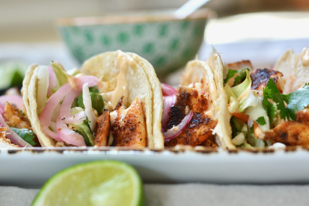 Super easy Blackened Fish Tacos with Tilapia, cilantro slaw and 2 ingredient sauce. Delicious taco night and summer meal.