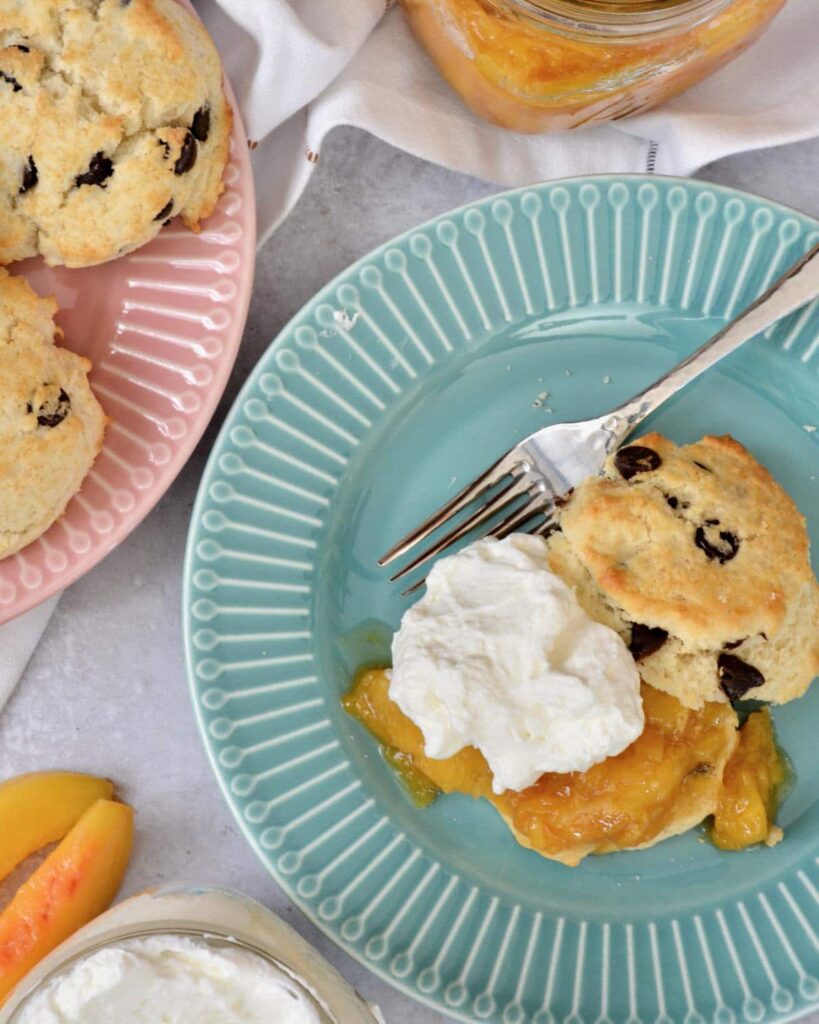 A twist on classic Peaches and Cream Shortbread with a splash of Breckenridge Gin. Tender and soft chocolate chip biscuits with homemade peach sauce and homemade whip cream. The BEST summer dessert!