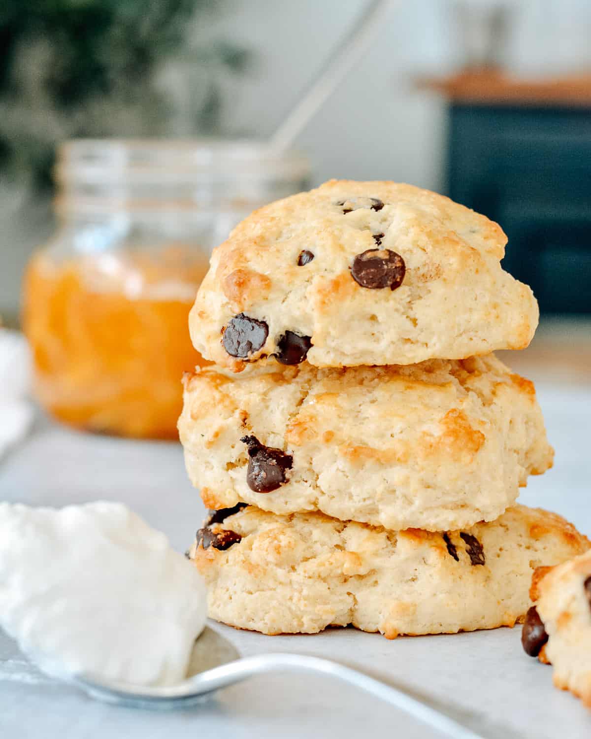 Stack of chocolate chip shortcakes with peaches in background.