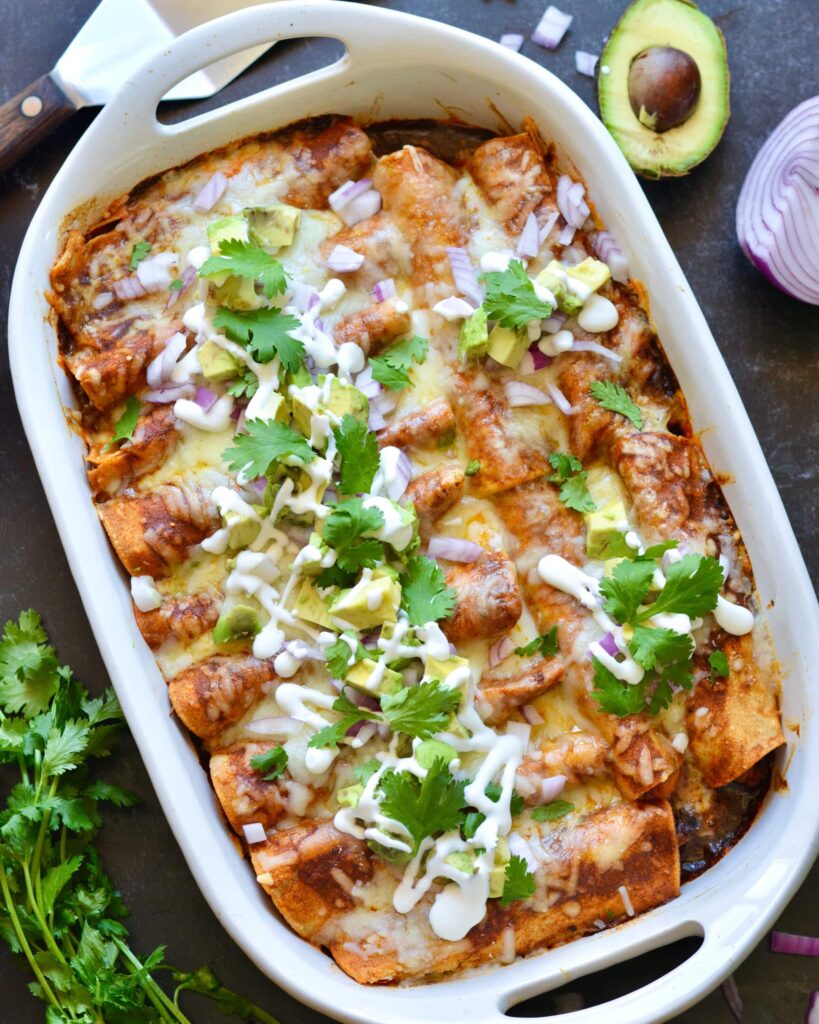 Delicious Make Ahead Enchiladas filled with Carnitas, Black Beans and Sweet Potatoes. Outstanding flavor combination of sweet, savory and spice. Simple homemade enchilada sauce recipe too!