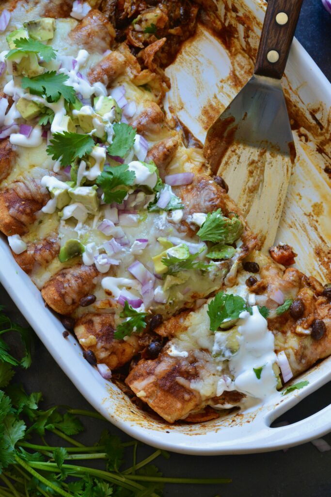 Delicious Make Ahead Enchiladas filled with Carnitas, Black Beans and Sweet Potatoes. Outstanding flavor combination of sweet, savory and spice. Simple homemade enchilada sauce recipe too!