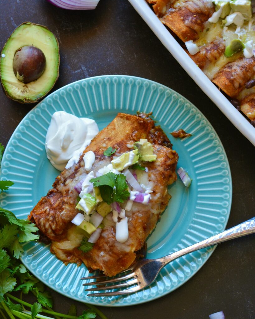 Delicious Make Ahead Enchiladas filled with Carnitas, Black Beans and Sweet Potatoes. Outstanding flavor combination of sweet, savory and spice. Simple homemade enchilada sauce recipe too!