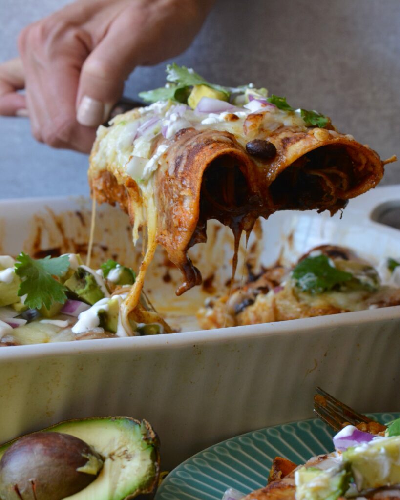 Delicious Make Ahead Enchiladas filled with Carnitas, Black Beans and Sweet Potatoes. Outstanding flavor combination of sweet, savory and spice. Simple homemade enchilada sauce recipe too!