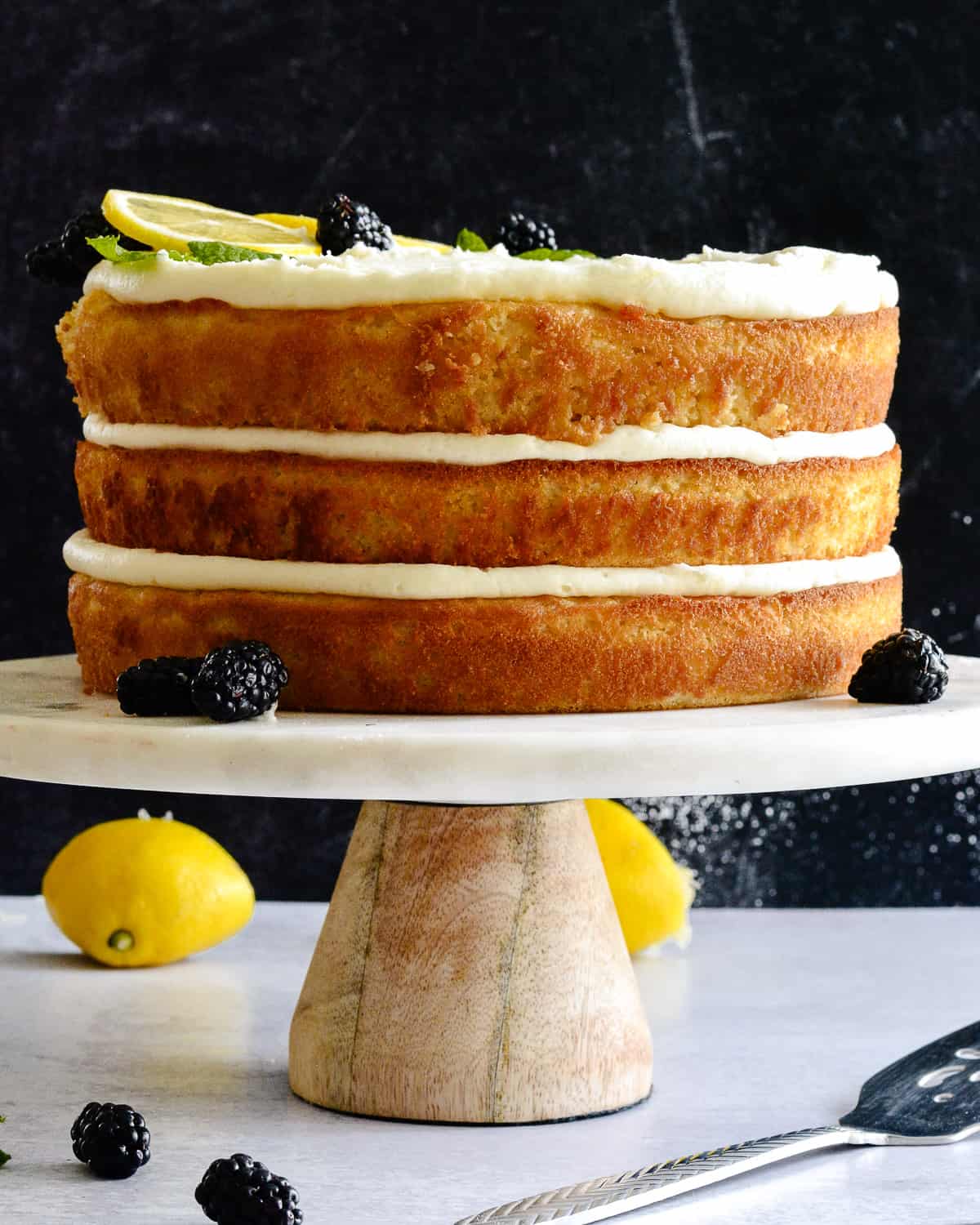 Side view of a 3 layer lemon cake on a cake plate.