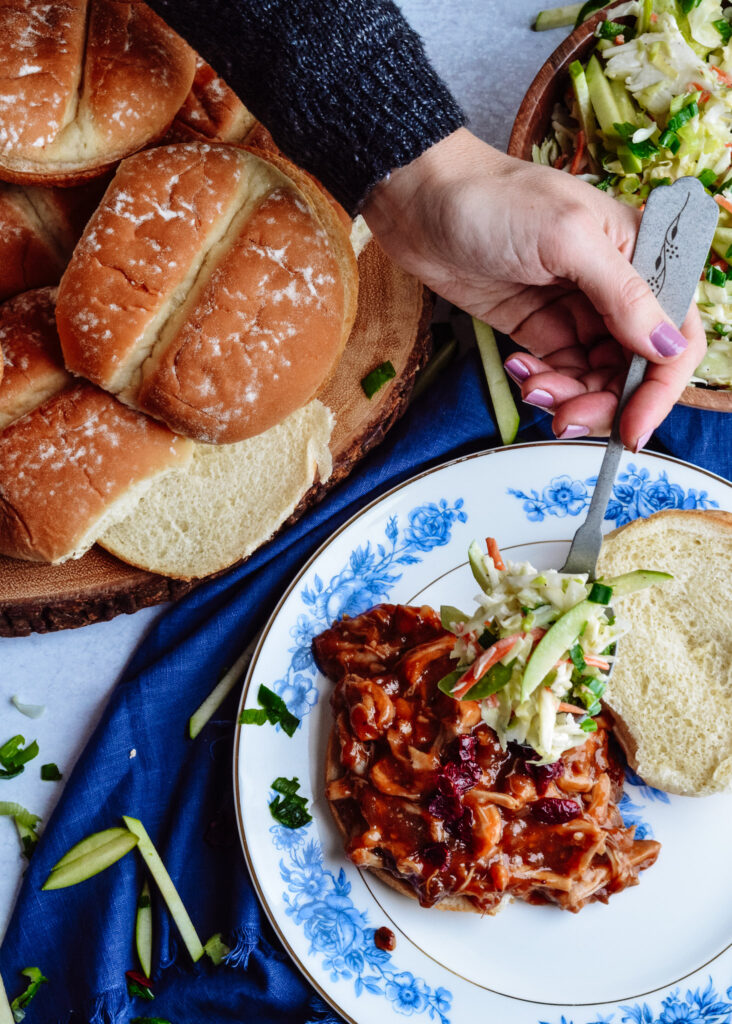 Cranberry BBQ Pulled Pork with Apple Slaw - slow cooker chicken thighs and make ahead slaw cuts dinner prep time to a minimum. Completely delicious meal the whole family will love!