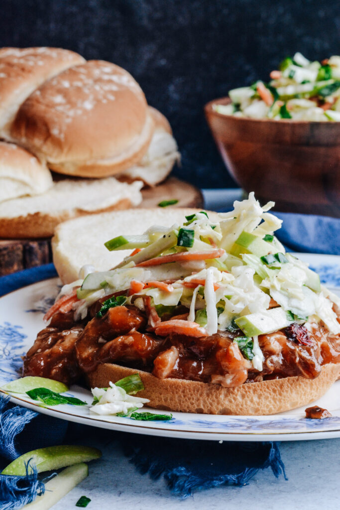 Cranberry BBQ Pulled Pork with Apple Slaw - slow cooker chicken thighs and make ahead slaw cuts dinner prep time to a minimum. Completely delicious meal the whole family will love!