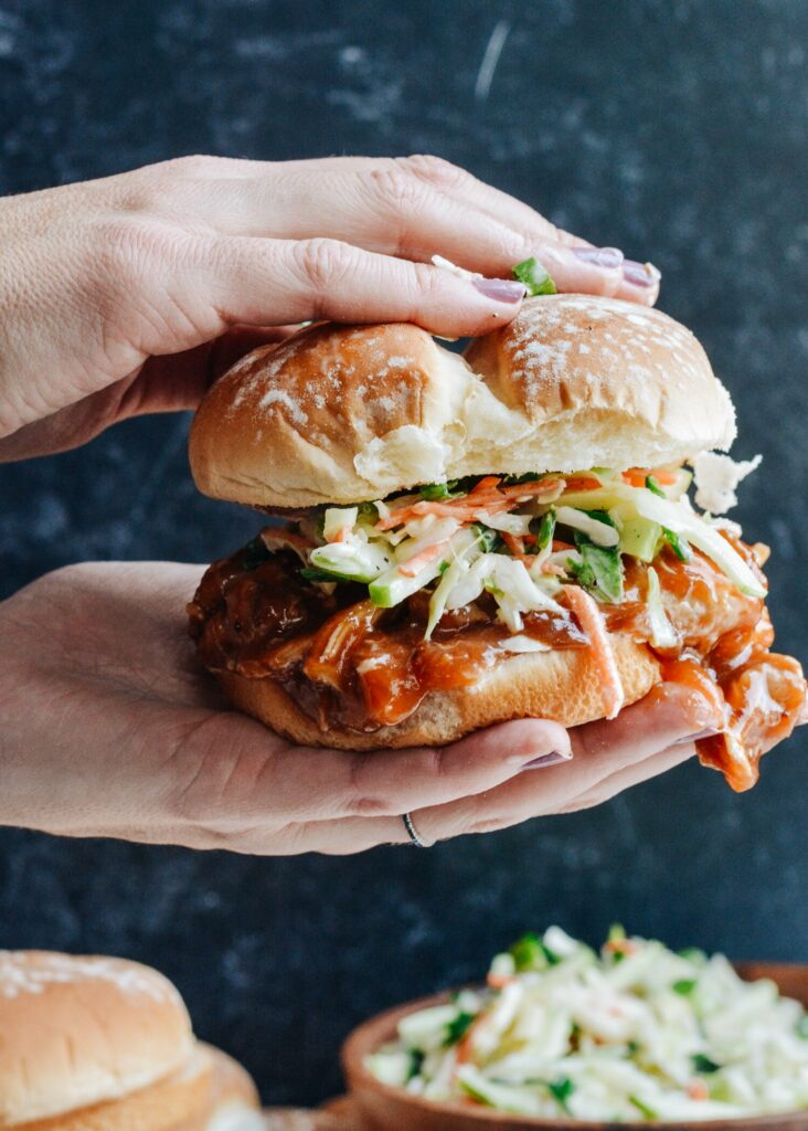 Cranberry BBQ Pulled Pork with Apple Slaw - slow cooker chicken thighs and make ahead slaw cuts dinner prep time to a minimum. Completely delicious meal the whole family will love!