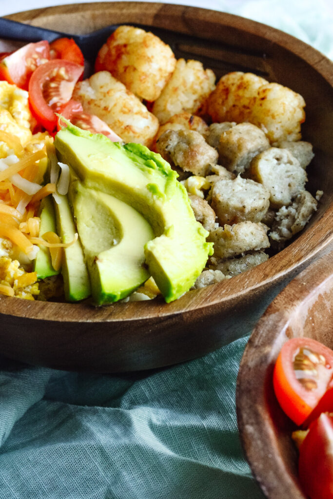 Simple Breakfast Hash—Perfect brunch hash, scrambled eggs, tater tots, cheese, avocado, sausage and toppings.