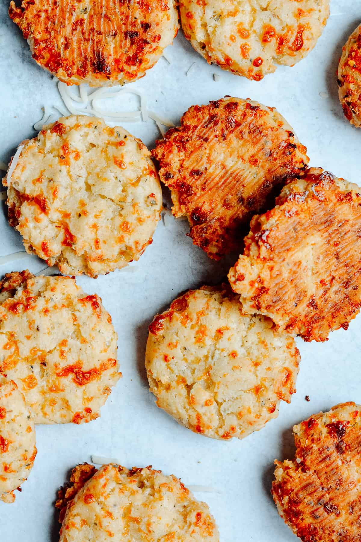 Tops and bottoms of cheese biscuits on countertop.