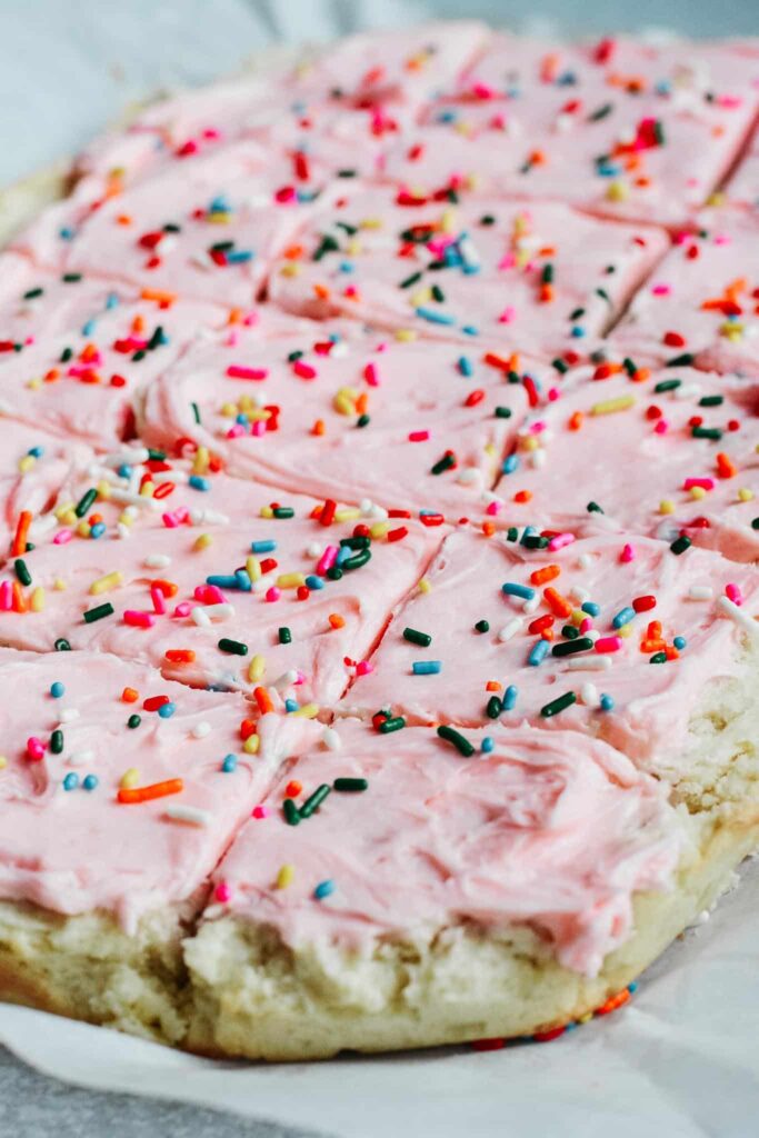 Soft and sweet with a delicate crumb, these Sugar Cookie Bars are made with a simple replacement gluten free flour. Topped with a not-too-sweet frosting and decorated with sprinkles. Kids and adults will love it! #sugarcookie #cookiebars #kidfriendly