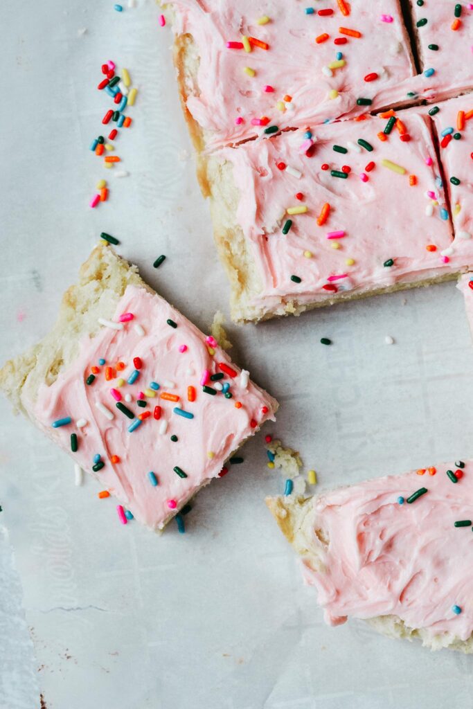 Soft and sweet with a delicate crumb, these Sugar Cookie Bars are made with a simple replacement gluten free flour. Topped with a not-too-sweet frosting and decorated with sprinkles. Kids and adults will love it! #sugarcookie #cookiebars #kidfriendly