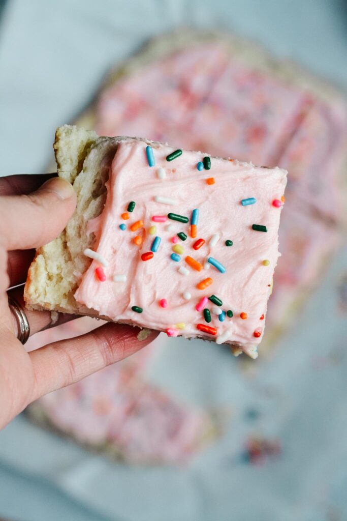 Soft and sweet with a delicate crumb, these Sugar Cookie Bars are made with a simple replacement gluten free flour. Topped with a not-too-sweet frosting and decorated with sprinkles. Kids and adults will love it! #sugarcookie #cookiebars #kidfriendly
