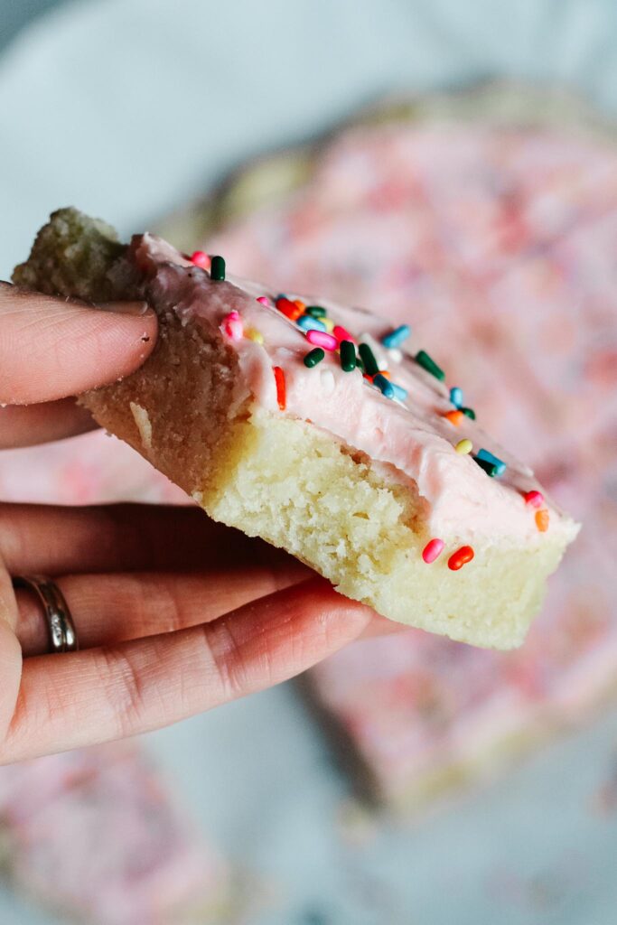 Soft and sweet with a delicate crumb, these Sugar Cookie Bars are made with a simple replacement gluten free flour. Topped with a not-too-sweet frosting and decorated with sprinkles. Kids and adults will love it! #sugarcookie #cookiebars #kidfriendly