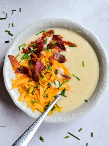 Up close Potato Soup with cheese, bacon and chives on top.