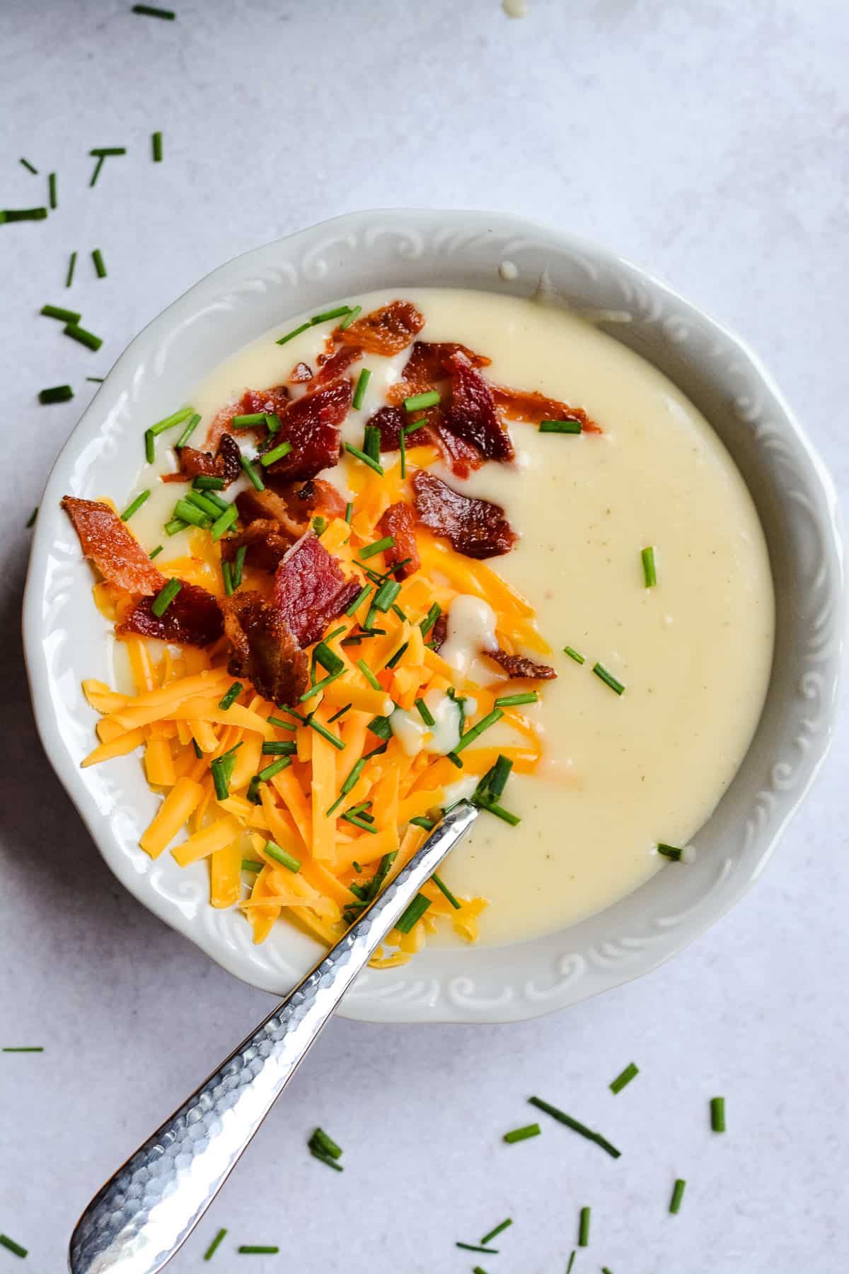 Up close Potato Soup with cheese, bacon and chives on top.