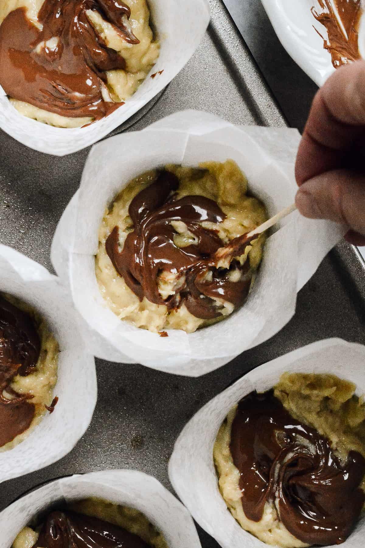 Close up of swirling nutella into banana batter.