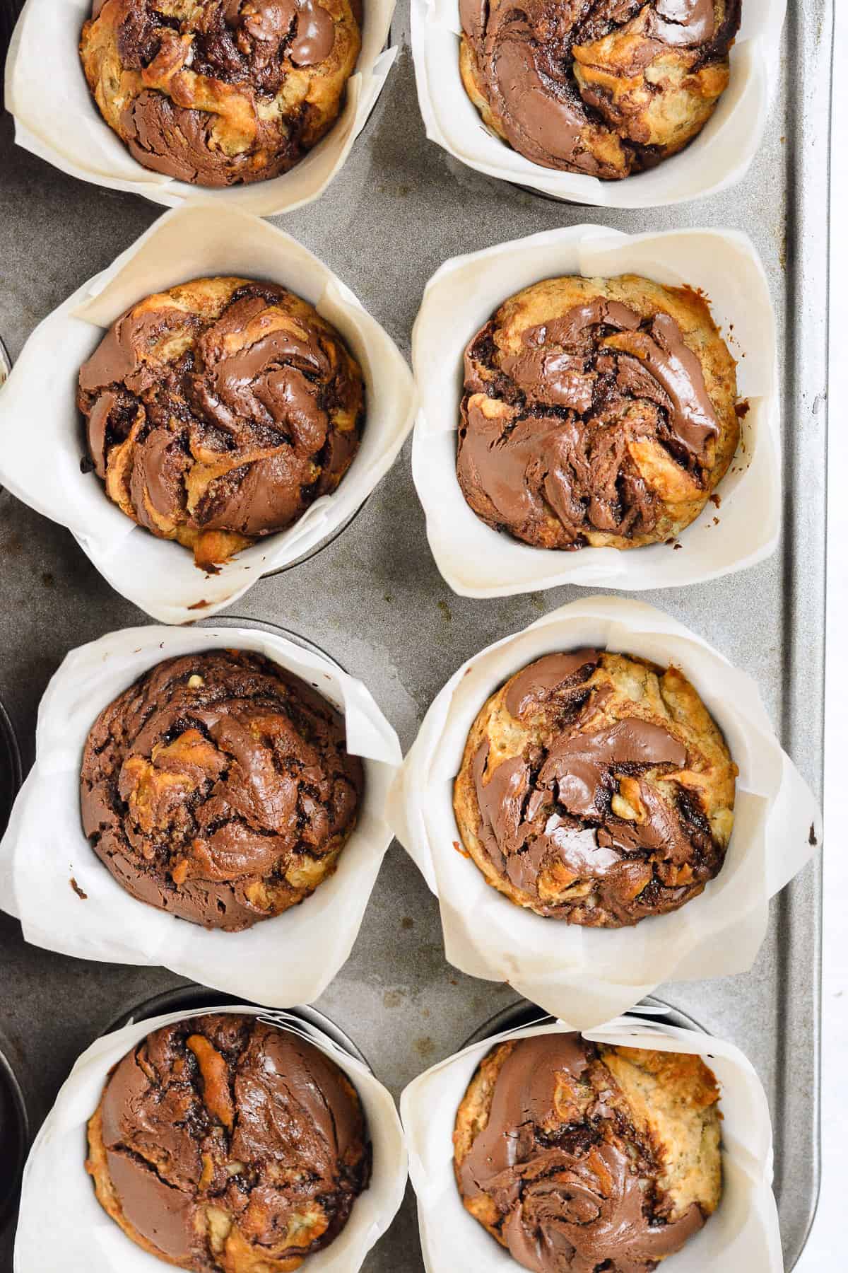 Nutella banana muffins in liners in the muffin tin.
