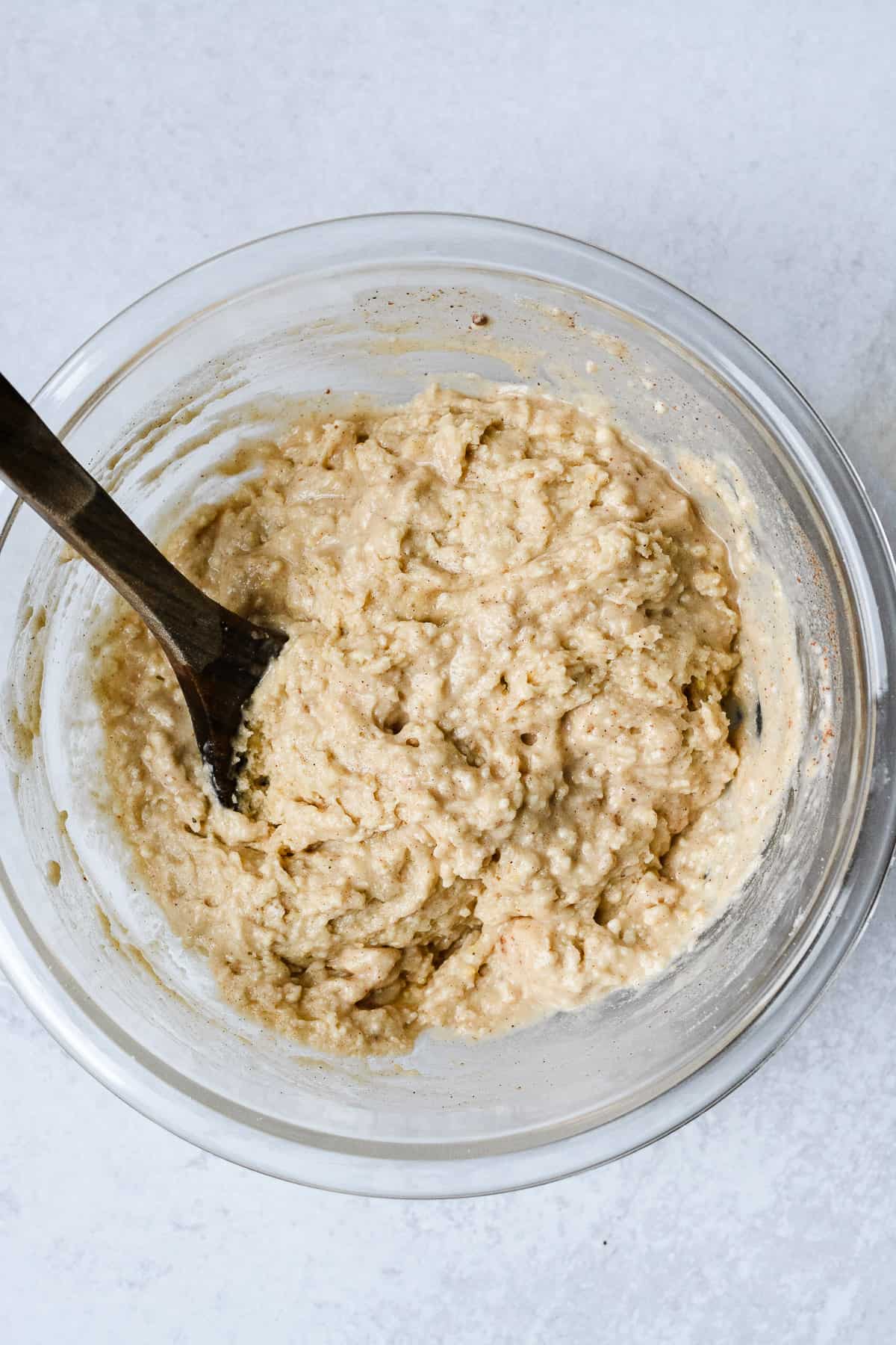 Mixed cake batter in bowl with wooden spoon.