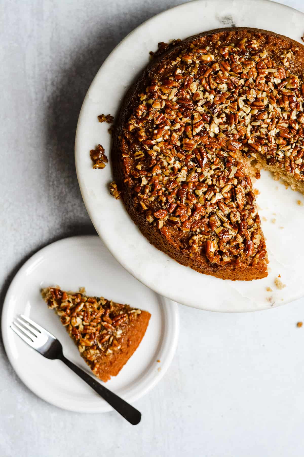 Pecan cake with slice on a plate with a fork. 