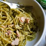 tuna pesto pasta in a bowl with parmesan in background