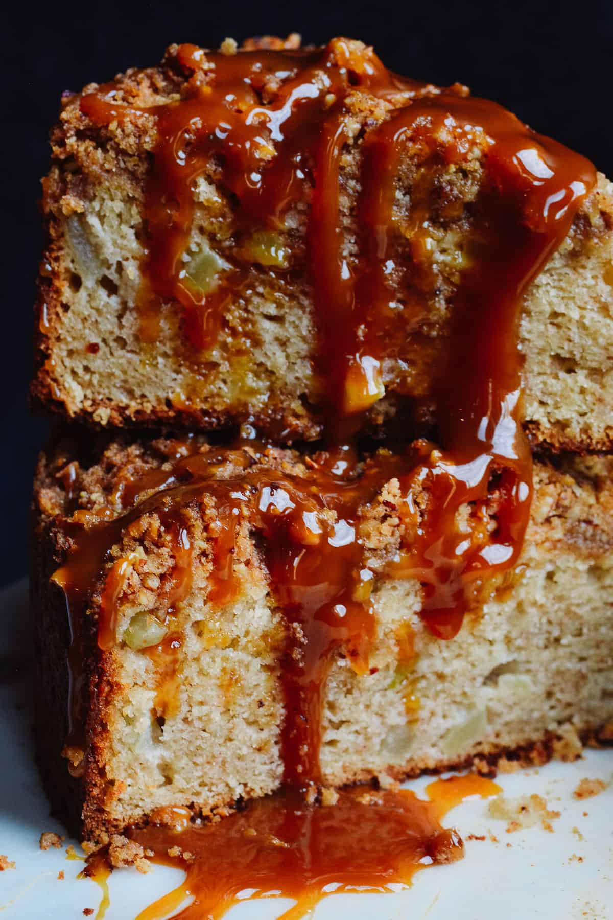 Caramel sauce drizzled over slices of caramel apple cake.